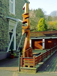 Die Skulptur der Hausnummer 157 ist nicht nur in der Haddenbacher Straße sondern in ganz Remscheid und über die Stadtgrenzen hinaus bekannt. Die etwa 6 Meter hohe Skulptur wurde aus dem gewachsenen Stamm eines Lebensbaumes geschnitzt.